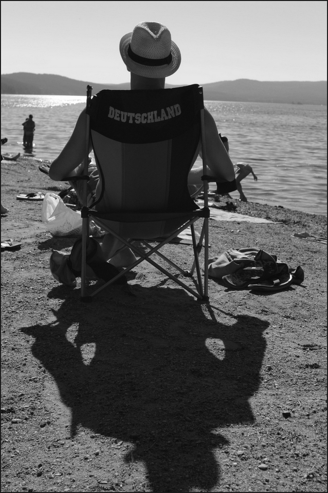 photo "***" tags: genre, black&white, beach, lake, man, shadow, кресло, латиница, надпись, шляпа